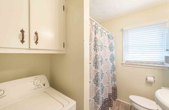 bathroom, laminate flooring, sink, toilet, tub/shower, laundry area