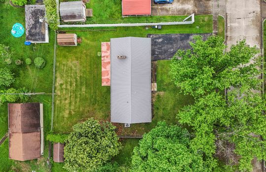 Aerial view of property, driveway, roof, back yard