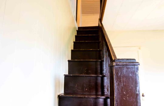 narrow wooden staircase to upper level loft