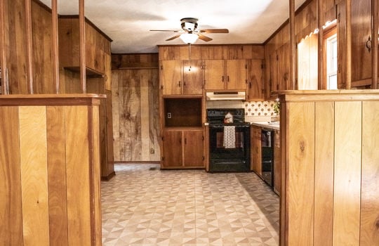 kitchen, oven/range, cabinets, vinyl flooring, ceiling fan, sink