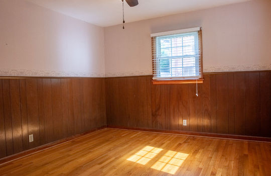 bedroom, wood paneling wainscoting, hardwood flooring, window, ceiling fan