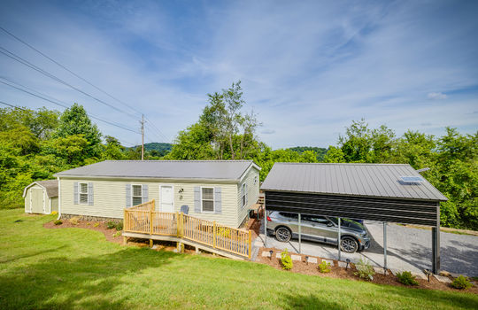 Double wide, manufactured home, front porch, ramp, front door, yard, carport, metal roof, vinyl siding, landscaping