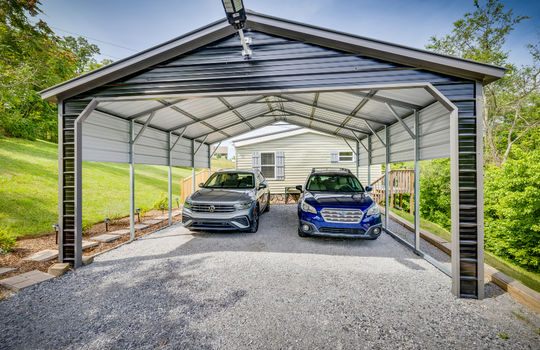 covered carport, two car carport, gravel, side view of home, double wide, manufactured home, vinyl siding, windows