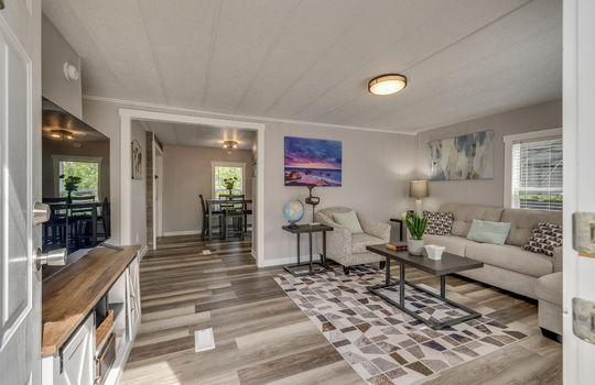 living room, laminate flooring, view into dining area