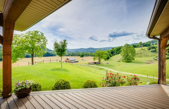 deck view from front door toward event venue barn, landscaping, mountain views