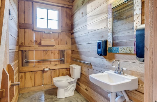 bathroom, event venue bathroom, wood walls, concrete flooring, sink, toilet