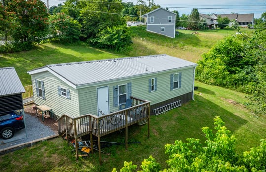 aerial back view of home, back deck, metal roof, vinyl siding, back door, windows