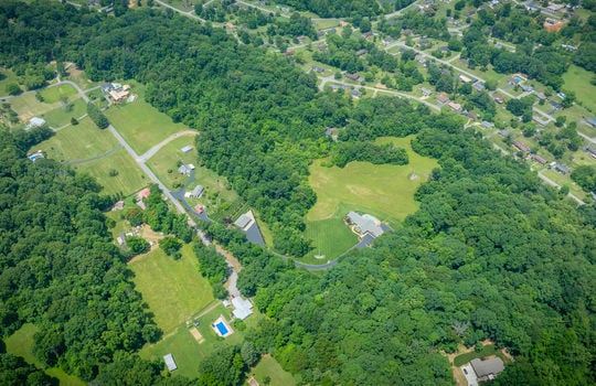 aerial view 25.72+/- acres, trees, woods, mountains, pasture, road, mountain views, house, road, neighboring properties