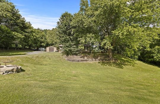 front yard, one level home, trees, sloping yard