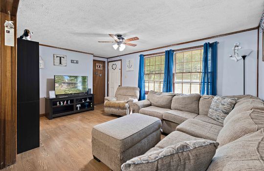 living room, vinyl flooring, ceiling fan, windows, front door