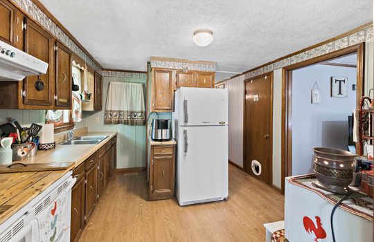 kitchen, vinyl flooring, range/oven, cabinets, countertops, sink, window above sink, refrigerator