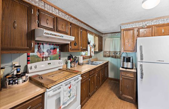 kitchen, vinyl flooring, range/oven, cabinets, countertops, sink, window above sink, refrigerator