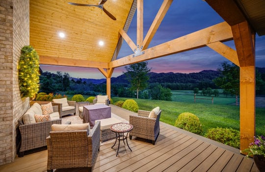covered front porch, outdoor fan, recessed lighting, twilight view of front yard, landscaping, mountain views