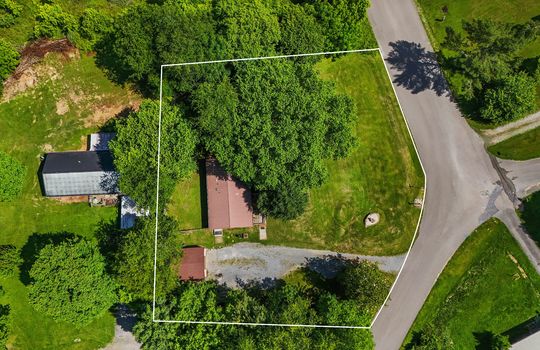 aerial view of property, gravel driveway, road, trees, front yard, back yard