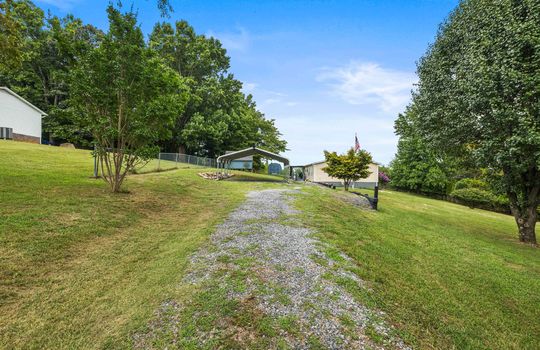 gravel driveway, carport, doublewide, vinyl siding