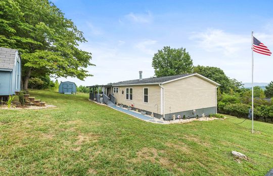 front yard, front porch, covered front oprch, front door, ramp, landscaping, vinyl siding, outbuilding