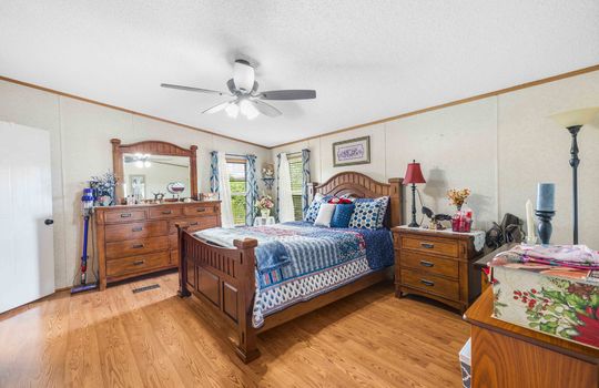 primary bedroom, luxury vinyl flooring, ceiling fan, window