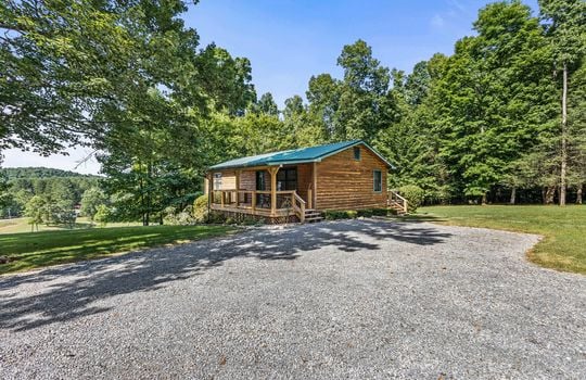 log cabin for lease, gravel driveway, yard, trees,