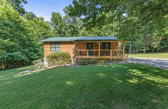 log cabin for lease, metal roof, porch, landscaping