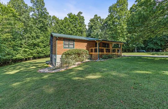 log cabin for lease, metal roof, porch, landscaping