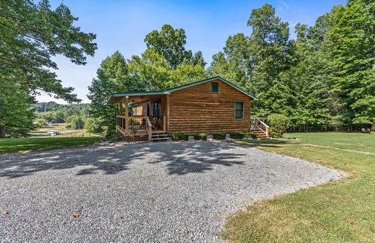 log cabin for lease, gravel driveway, yard, trees,