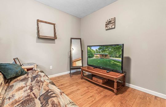 bedroom, hardwood flooring, furnished, bed, mirror, tv stand