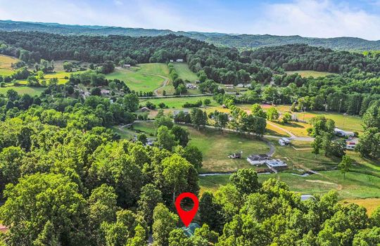 Aerial view of neighborhood, trees, mountains, property marker