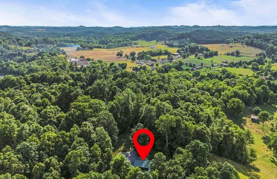 Aerial view of neighborhood, trees, mountains, property marker