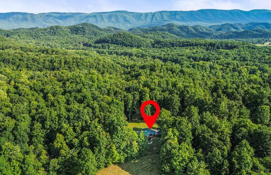 Aerial view of neighborhood, trees, mountains, property marker