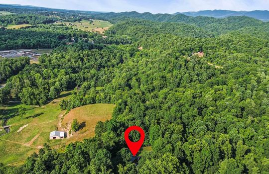 Aerial view of neighborhood, trees, mountains, property marker