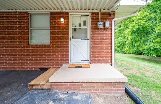 exterior entry from carport, brick exterior, storm door, steps