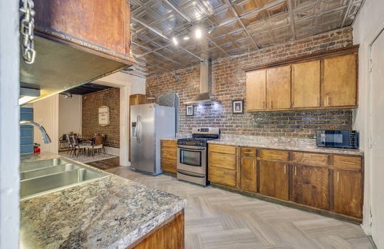 kitchen, refrigerator, stove, cabinets, countertops, exposed brick, sink