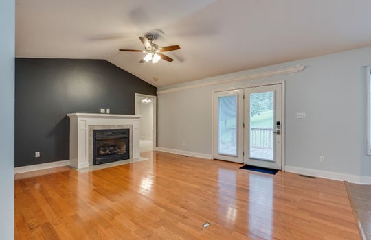 Living room, ceiling fan, double door exterior door, hardwood flooring, fireplace