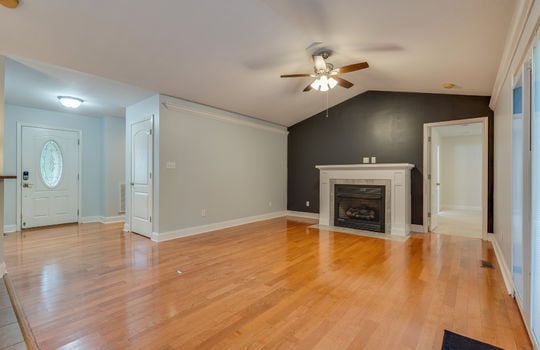 Living room, ceiling fan, double door exterior door, hardwood flooring, fireplace