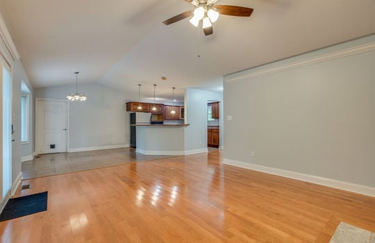 living room view into dining area/kitchen, hardwood flooring, breakfast bar, ceiling fan