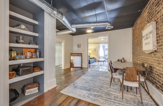 dining area, storage/pantry, hardwood flooring, exposed brick wall