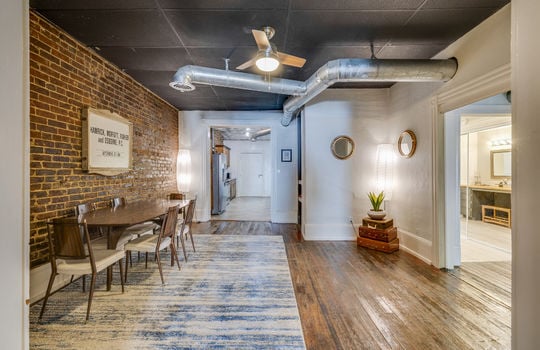 dining area, exposed brick, hardwood flooring, ceiling fan, view into kitchen