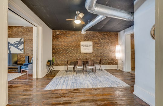 dining area, exposed brick wall, hardwood flooring, ceiling fan