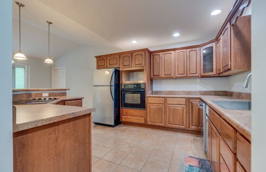 kitchen, tile flooring, recessed lighting, refrigerator, wall oven, cooktop in island, sink, cabinets, countertops