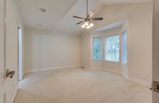 primary bedroom, bay window, ceiling fan, carpet, door to ensuite