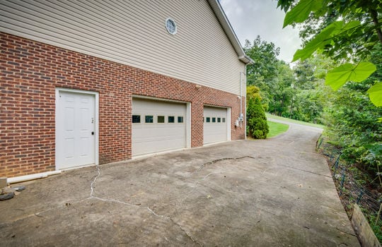 exterior entry door, driveway, lower level drive under garage, two bay garage