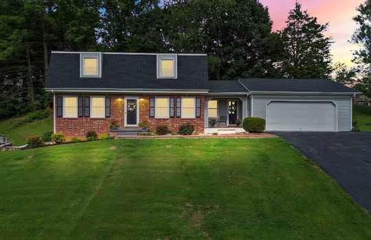 Twilight photo, brick, dutch colonial, front door, garage door, front yard, trees