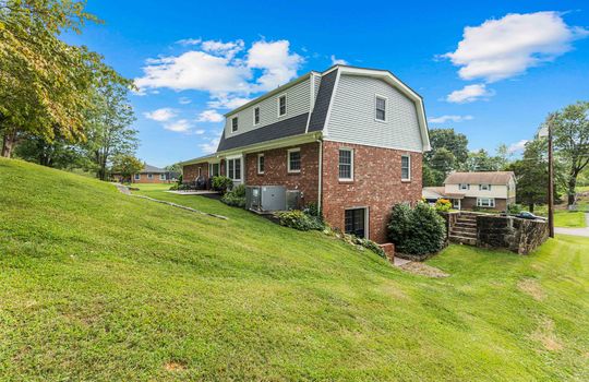 back right side view of home, back yard, patio, dutch colonial home, brick, vinyl siding