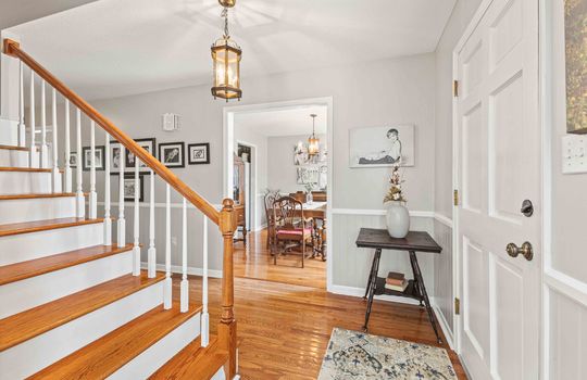 entryway, front door, stairs to upper level, view into dining area