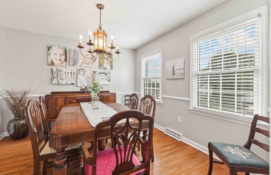 dining area, hardwood flooring, chandelier, windows, chair railing