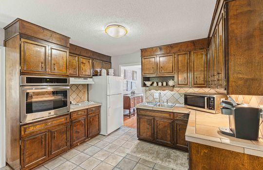 kitchen, cabinets, wall oven, refrigerator, countertops, tile flooring