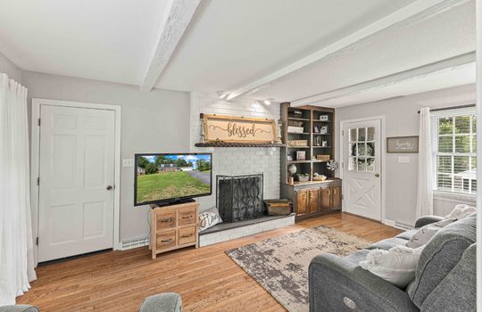 living room, hardwood flooring, fireplace, exterior door