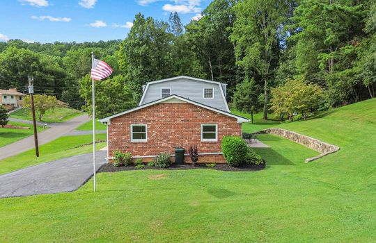 side view of home, brick exterior, dutch colonial style home, flag pole, driveway