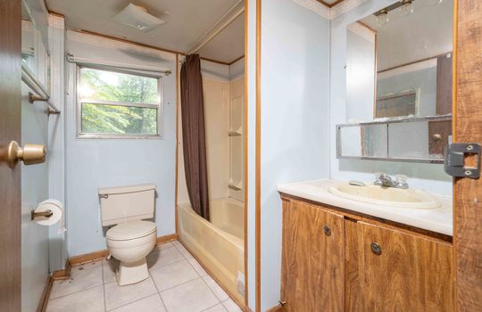 bathroom, toilet, laminate flooring, tub/shower, sink