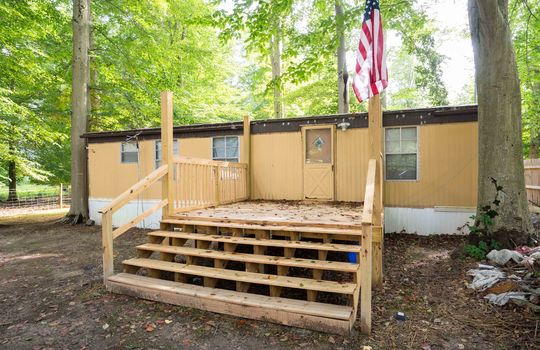 doublewide exterior, vinyl siding, front door, front deck, front yard, trees